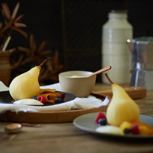 Poached Citrus Pears on plates with fruits on the side