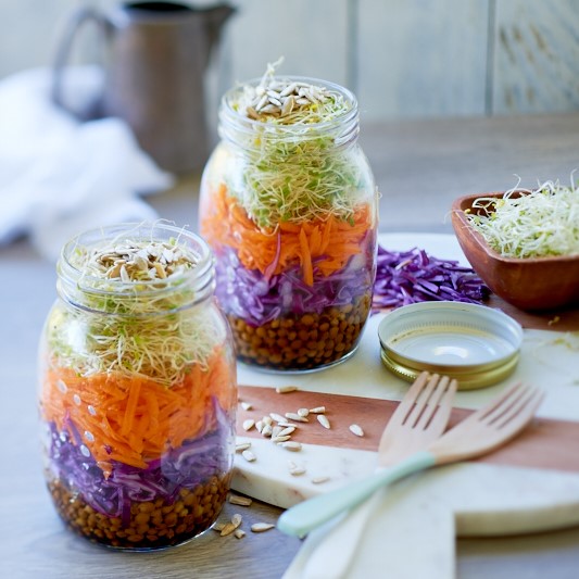 Jars of Rainbow Salad on a light wooden background photo