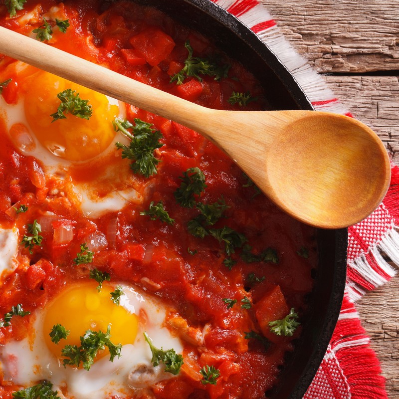 Pan of Shakshuka Fried Eggs on Wooden Background