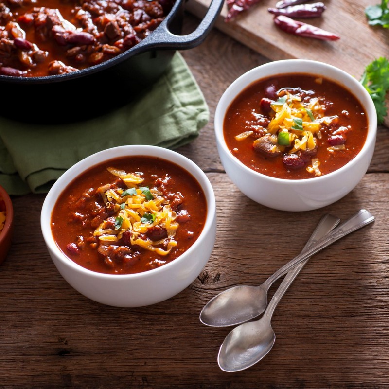 Two Bowls of Spicy Bean Hotpot on Wooden Table