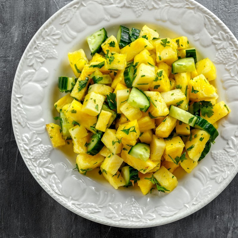 Bowl of Spicy Cucumber Pineapple Salad on Gray Background