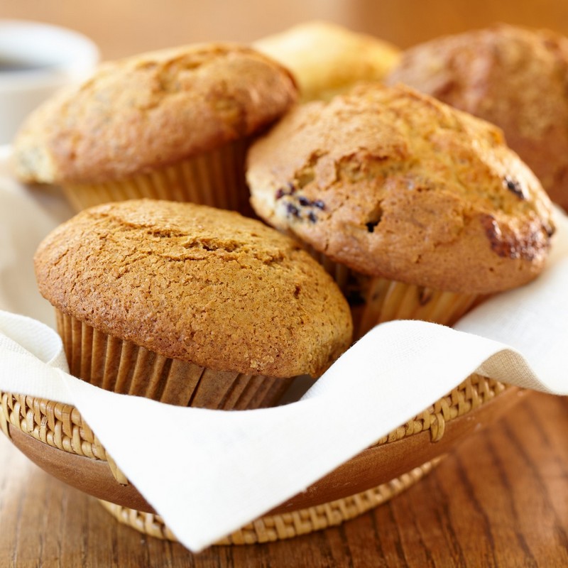Freshly baked muffins on a wooden bowl close up photo